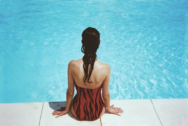 žena sedící na kraji bazénu